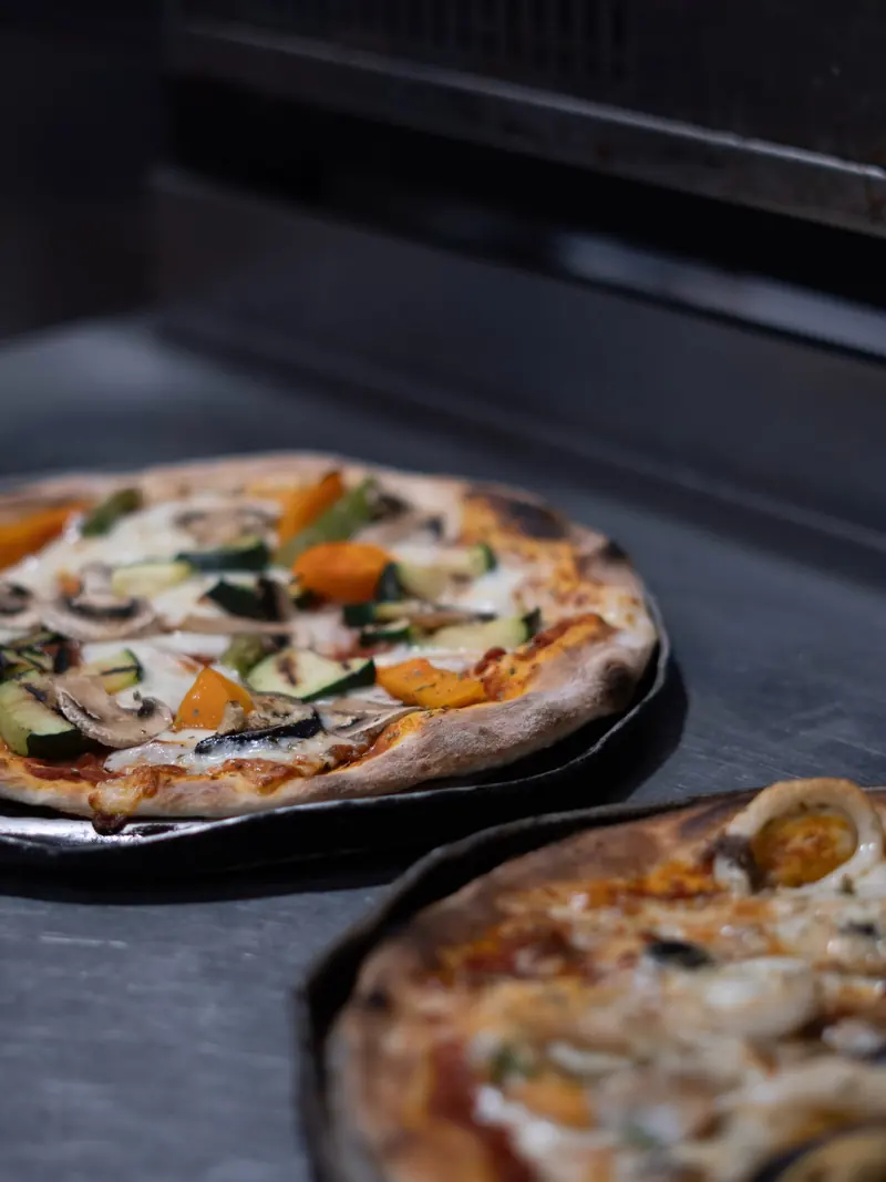 Dos pizzas de masa fina recién salidas del horno