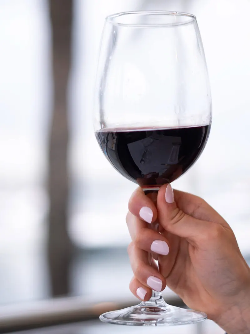 Copa de vino tinto junto a la ventana